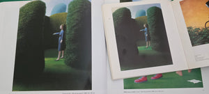 Dolf Zwerver, Woman in a Garden (1988), oil on panel depicting a woman in a blue dress standing between tall green hedges in an enclosed garden pictured in 2 books