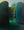 Dolf Zwerver, Woman in a Garden (1988), oil on panel depicting a woman in a blue dress standing between tall green hedges in an enclosed garden without the frame.
