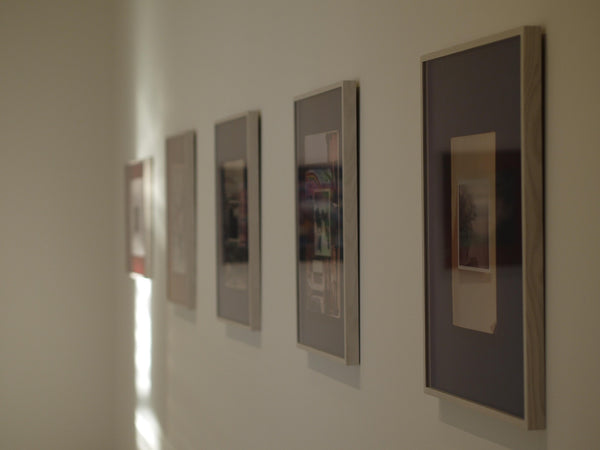 Atmospheric image of framed artworks on a wall