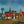 big painting by Toon Tieland, oil on canvas, village with bright colors and three figures
